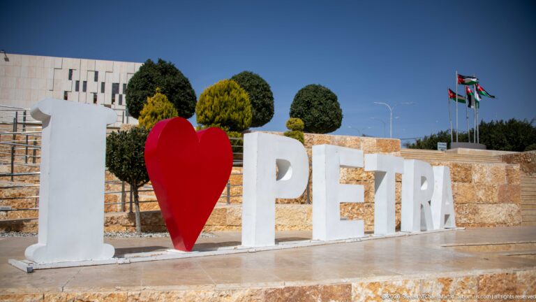 White I and PETRA letters with a red heart beside landscaped stone terraces and Jordanian flags.
