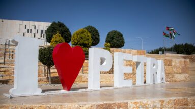 White I and PETRA letters with a red heart beside landscaped stone terraces and Jordanian flags.