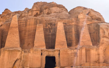 Four tall tapering rock-cut obelisks rise above the doorway of Petra’s Obelisk Tomb.