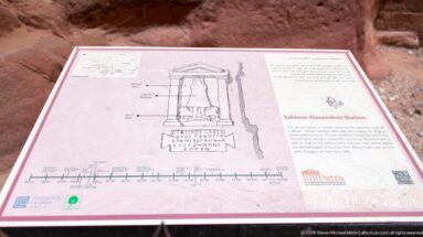 Interpretive panel titled Sabinos Alexandros Station with niche drawing, Arabic and English text, site plan, and timeline.