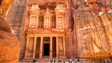 Vertical view of Petra’s Treasury showing lower columns, dark entrance, triangular pediment, and upper tholos.