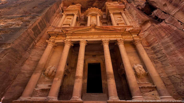 Full frontal view of Al-Khazneh, Petra’s Treasury, with its two-story columned façade carved into rose sandstone.