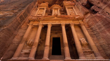 Full frontal view of Al-Khazneh, Petra’s Treasury, with its two-story columned façade carved into rose sandstone.