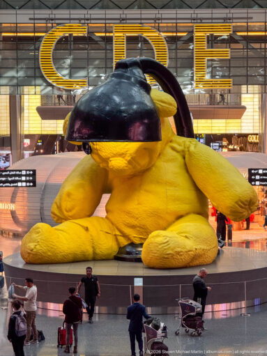 Urs Fischer's giant yellow Lamp Bear beneath a black desk-lamp shade in Hamad International Airport.