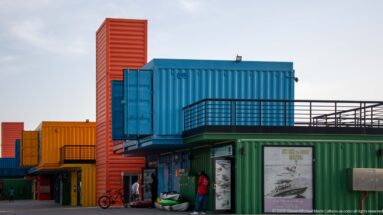 Bright blue, green, orange, and red shipping containers converted into shops and visitor spaces at Box Park in Doha.