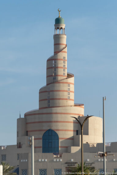 Spiral minaret of Fanar above the pale Qatar Islamic Cultural Center building in Doha.