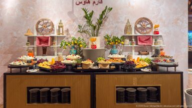 Decorative Farm House buffet with fruit, desserts, flowers, bowls, and rustic wagon-wheel ornaments.
