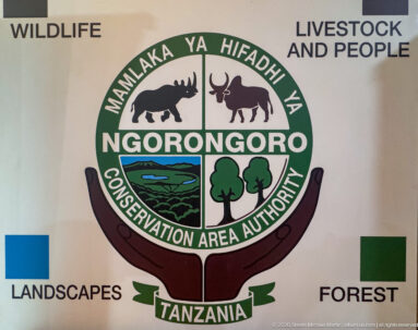 Large Ngorongoro Conservation Area Authority emblem with animal, landscape, and tree symbols beside thematic labels.