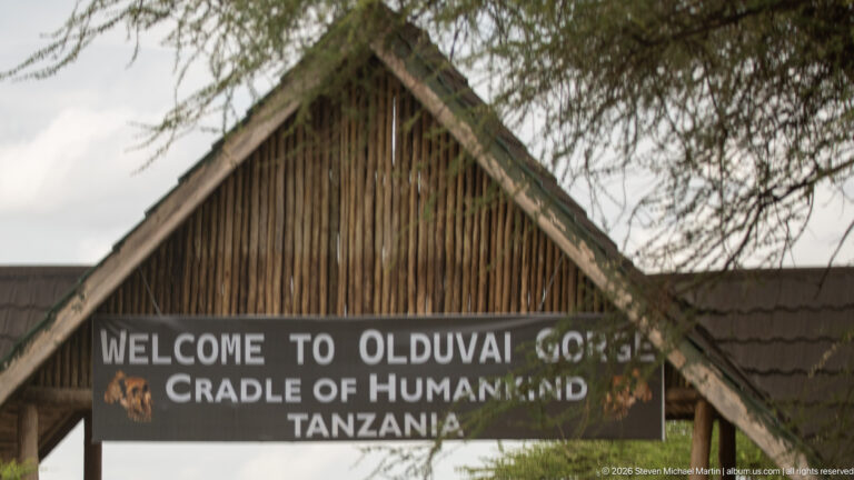 Close view of the gateway sign reading “Welcome to Olduvai Gorge, Cradle of Humankind, Tanzania.”
