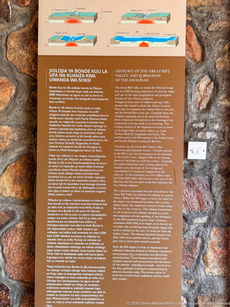 Geology panel with cross-section diagrams mounted on a rough stone wall in the Olduvai museum.