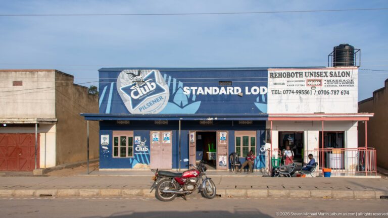 Standard Lodge and Rehoboth Unisex Salon occupy a low roadside building with a motorcycle parked in front.
