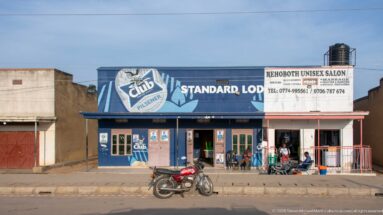 Standard Lodge and Rehoboth Unisex Salon occupy a low roadside building with a motorcycle parked in front.
