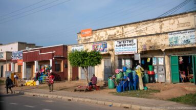 Tateitwe Supershop and neighboring storefronts display colorful plastic household goods along the roadside in Kihihi.
