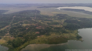 Wooded peninsula with scattered settlement, roads, wetlands, and broad water on several sides.