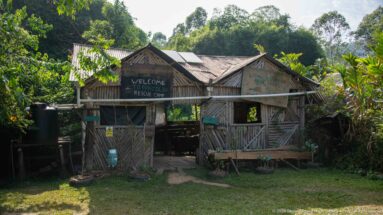 Rustic Pangolin Rescue Center building made of woven bamboo and timber, with a welcome sign across the open entrance.
