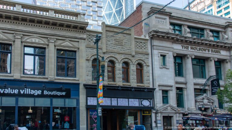 Historic Calgary commercial façades beside the former Molson’s Bank, with a modern high-rise rising behind.