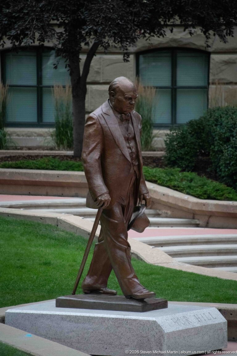 One bronze businessman from William Hodd McElcheran’s Conversation carrying a briefcase and umbrella on Stephen Avenue.