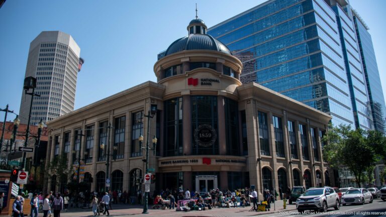 National Bank building at Stephen Avenue and 2 Street SW, with domed corner pavilion, arched windows, and modern towers behind.