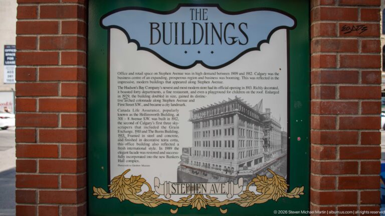Stephen Avenue heritage panel titled The Buildings, with explanatory text and a historic building photograph in a green frame.