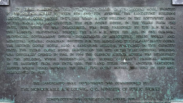 Weathered bronze historical plaque with text describing Calgary’s original courthouse, sandstone building, later demolition, and site development.