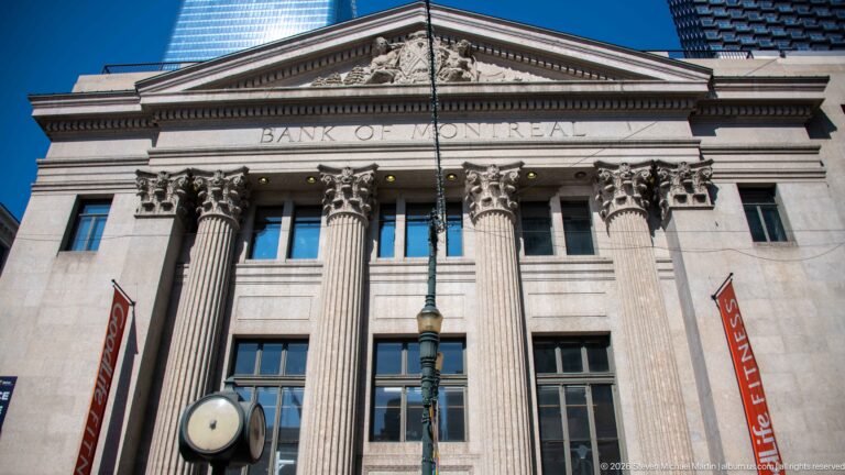 Bank of Montreal classical stone façade with tall fluted columns, carved name, and sculpted triangular pediment.