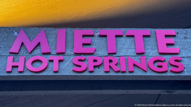 Raised magenta letters spelling Miette Hot Springs on a weathered horizontal board.