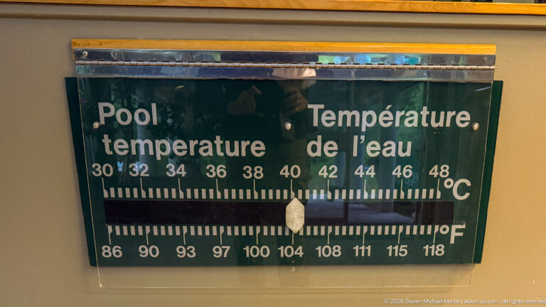 Bilingual pool temperature gauge with Celsius and Fahrenheit scales, pointer near 40 degrees Celsius and 104 degrees Fahrenheit.