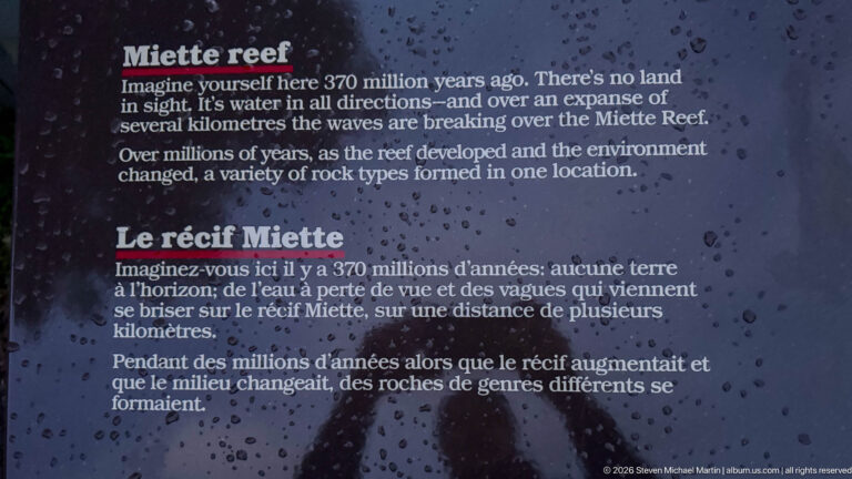 Rain-speckled bilingual interpretive panel titled Miette Reef and Le récif Miette with explanatory text.