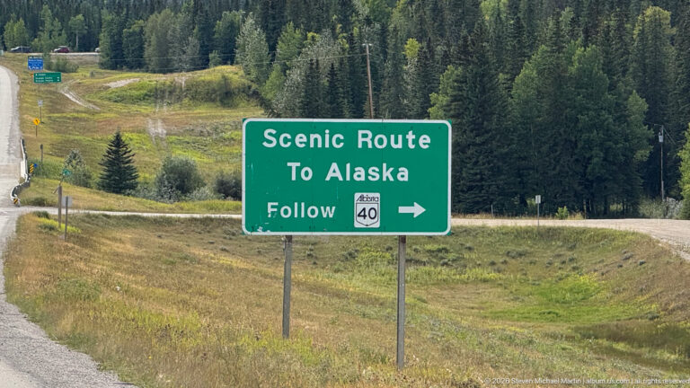 Green roadside sign reading Scenic Route To Alaska and Follow Alberta 40 with a right-pointing arrow.