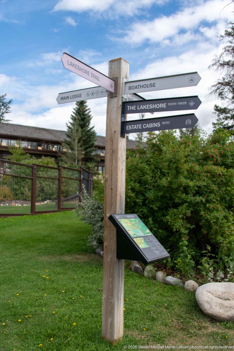 Wooden Jasper Park Lodge wayfinding post pointing to the main lodge, boathouse, trails, and cabins.