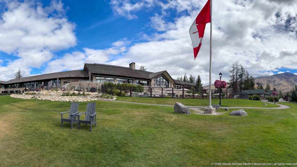 Broad lawn with chairs, Canadian flag, Jasper Park Lodge buildings, landscaping, and mountains.