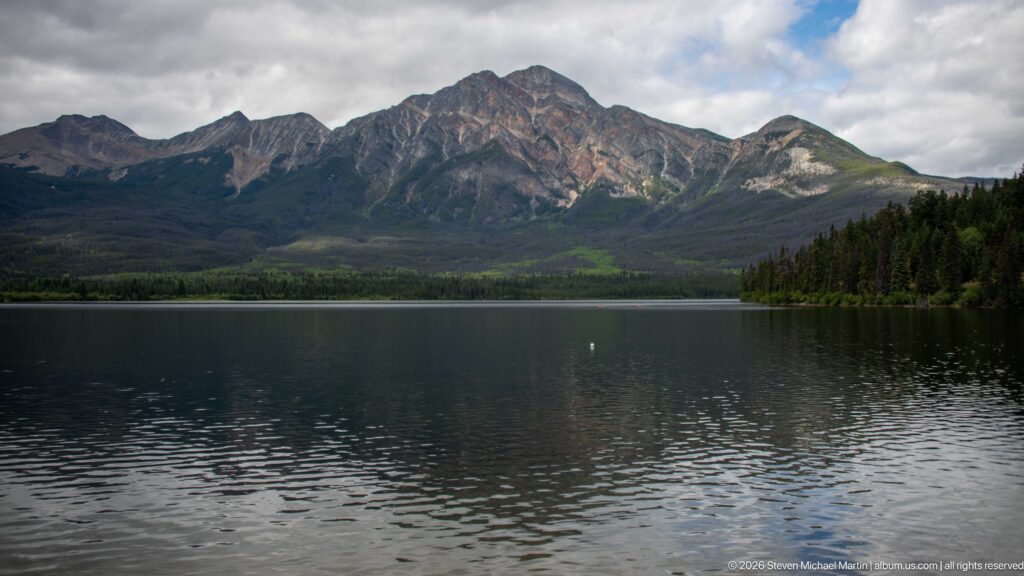 Wide view across Pyramid Lake toward a rugged mountain, with a forested point entering from the right.