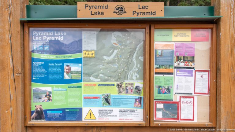 Wooden Pyramid Lake information board displaying a map, trail information, notices, and safety panels.
