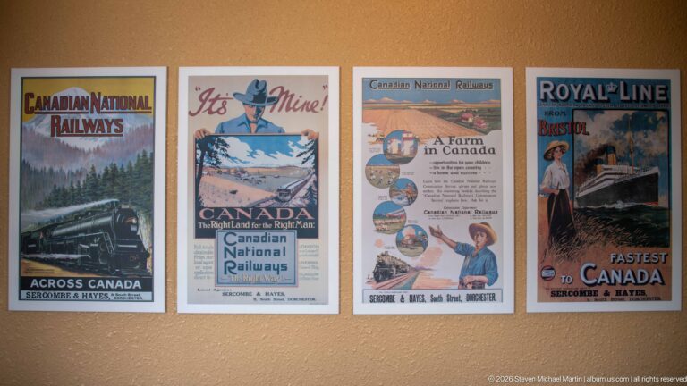 Four colorful historic Canadian railway posters mounted in a row on an interior wall.