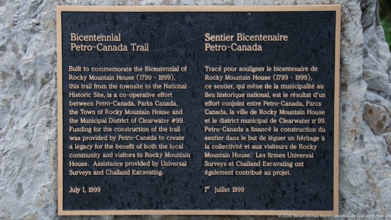 Bilingual bronze Petro-Canada Trail bicentennial plaque mounted on a stone surface.