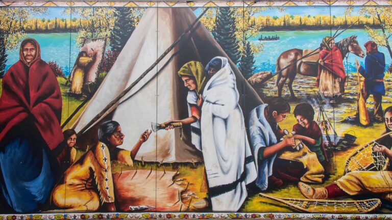 Colorful mural with a tipi, Indigenous figures in blankets, people working on the ground, horses, and forest beyond.