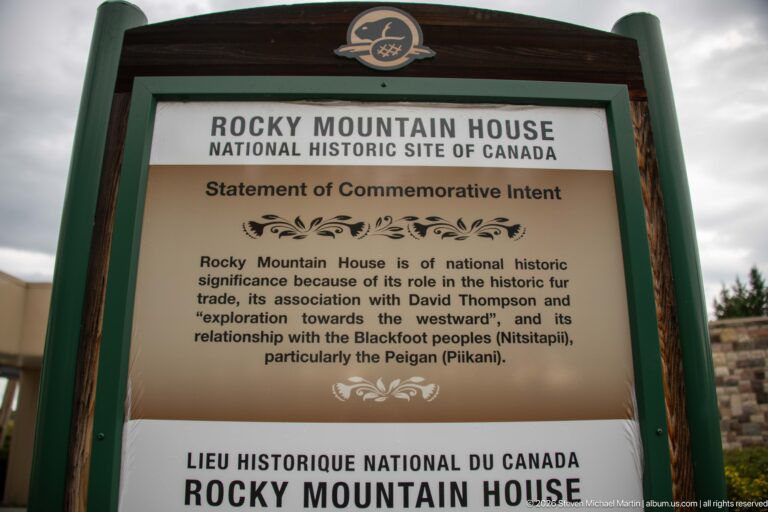 Framed Rocky Mountain House National Historic Site sign with the English Statement of Commemorative Intent and French section below.