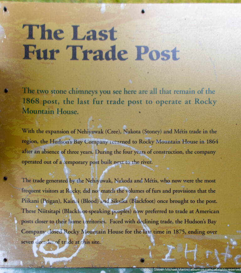 Weathered yellow panel titled 'Last Fur Trade Post' describing the 1868 post, two surviving stone chimneys, and closure in 1875.
