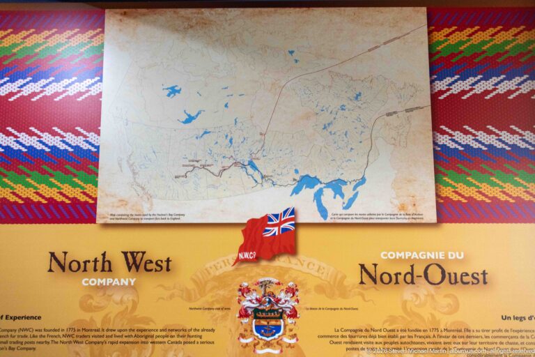North West Company exhibit with regional map, bilingual text, heraldic crest, and patterned border.