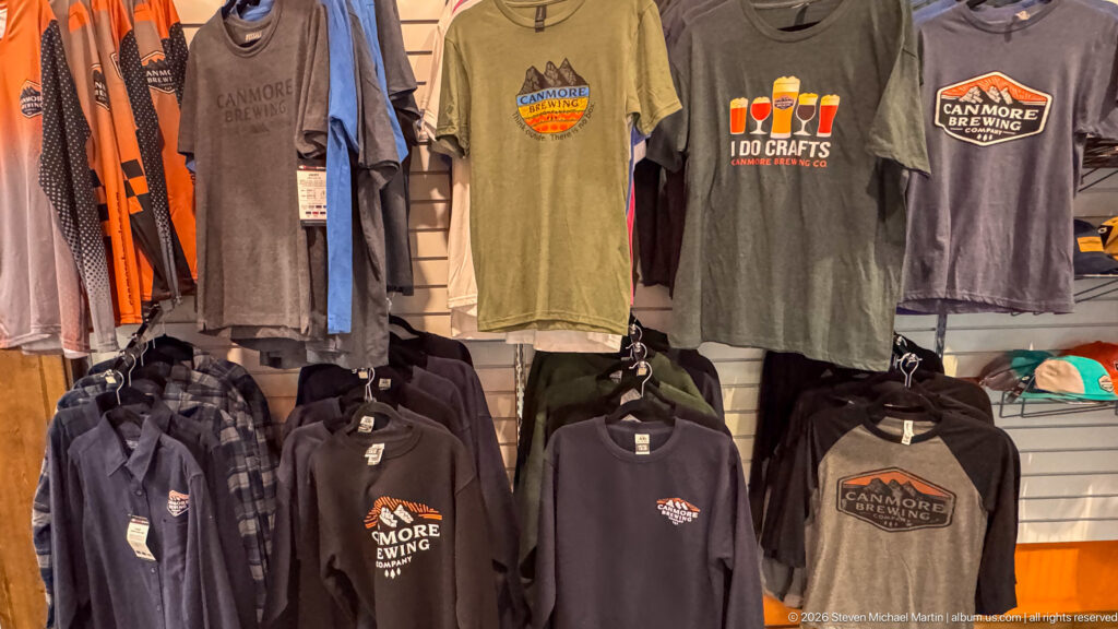 Canmore Brewing Company T-shirts and sweatshirts hang above shelves of caps and merchandise.