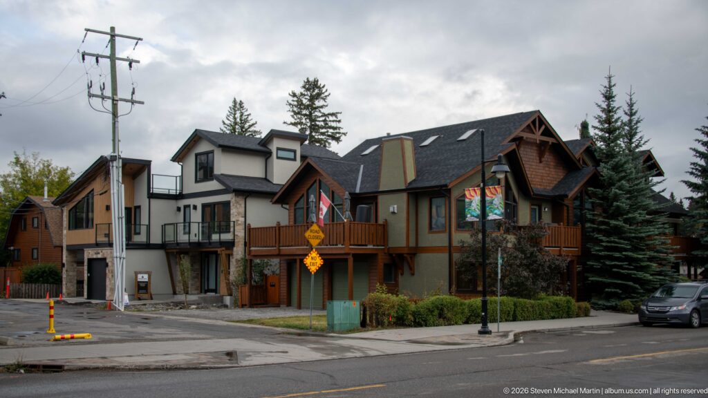 Modern townhomes with balconies, timber details, and steep roofs line a Canmore street.