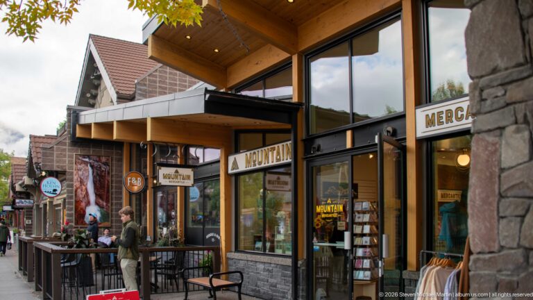 A Mountain Mercantile storefront with timber framing and a narrow sidewalk patio.