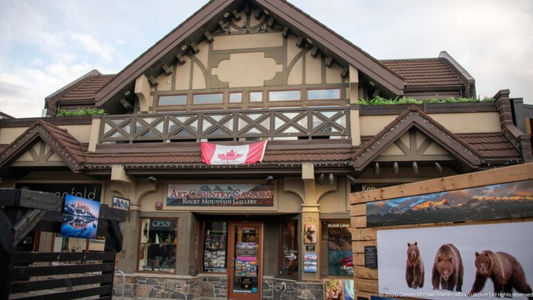 Art Country Canada displays painted wildlife and mountain scenes beneath a Canadian flag.