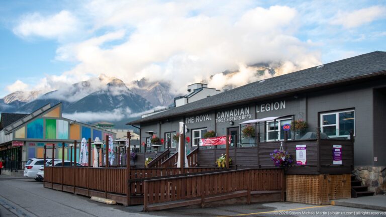 The Royal Canadian Legion sign spans a low storefront above a raised wooden patio and flower baskets.