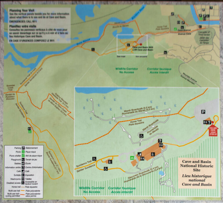 Bilingual site map with colored trails, roads, facility symbols, and an enlarged inset of the grounds.