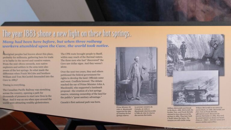 A bilingual panel about 1883 pairs explanatory text with archival photographs of the hot springs.