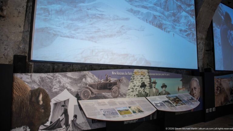 A curved history panel sits beneath a wall-sized mural and projected mountain landscape.