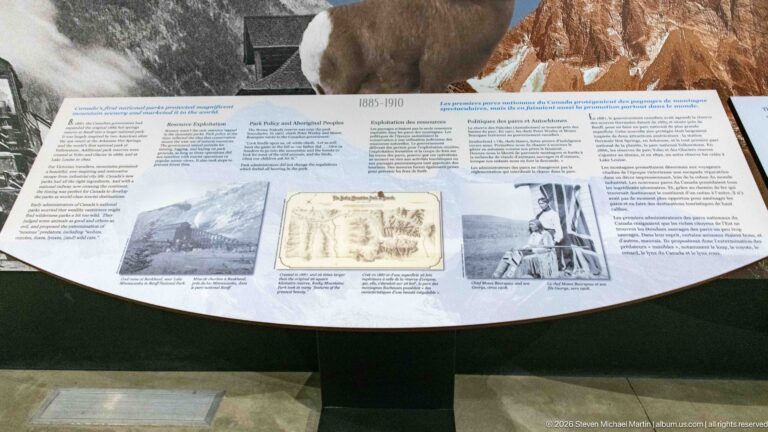 An 1885–1910 exhibit panel displays a historic map between photographs and bilingual text.