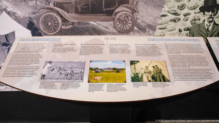 A curved 1911–1935 history panel sits beneath an archival mural with an early automobile.