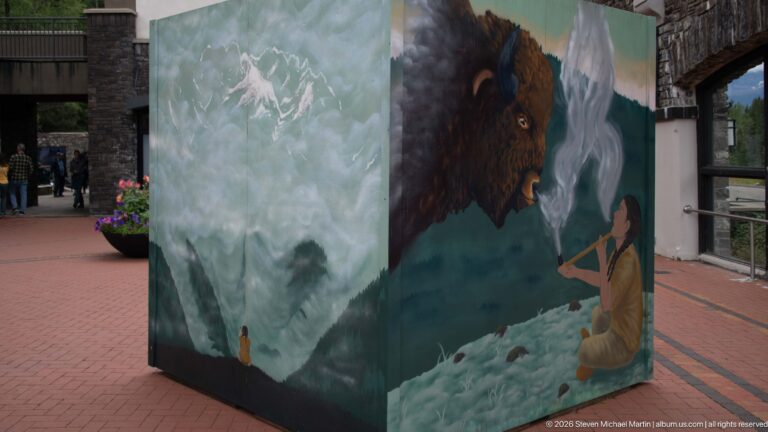 A wraparound exhibit panel pairs a bison portrait with a mountain scene in the courtyard.
